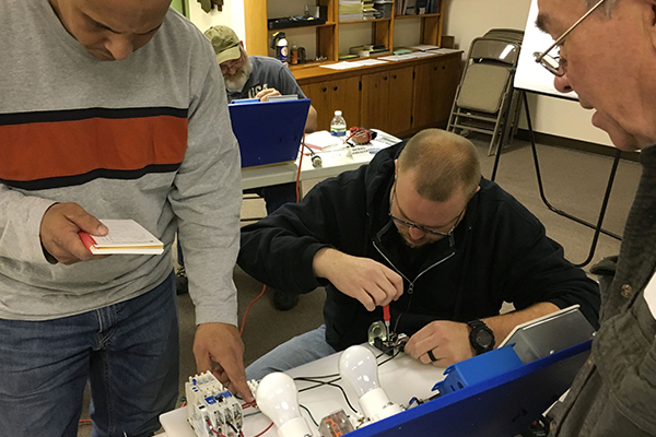 Students working on reassembling a piece of machinery