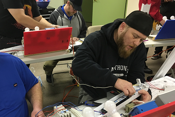 Student troubleshooting a broken lamp in class