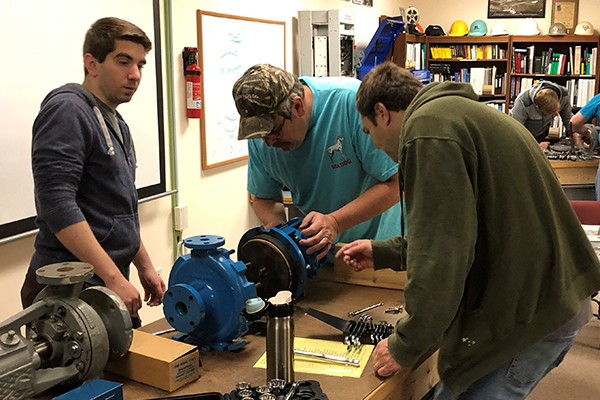 Students rebuilding a pump