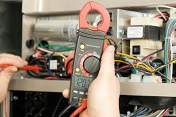 Picture of a voltage meter troubleshooting an AC unit.