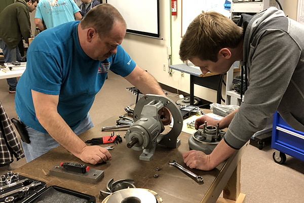 Two students installing a mechanical seal.
