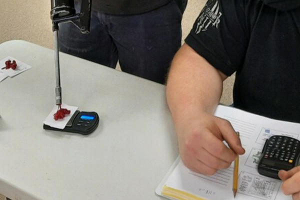 Student performing a Grease Gun Calibration