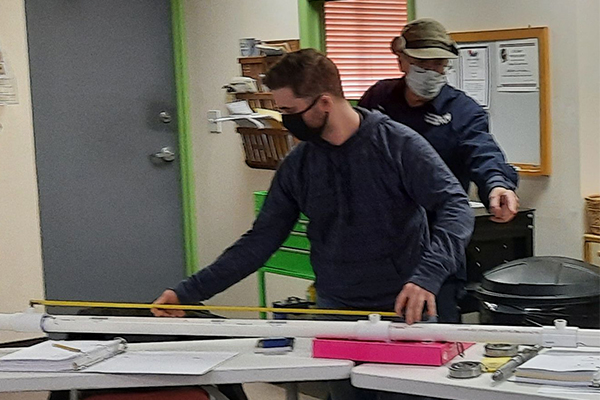 Student checking pipe length to calculate water head